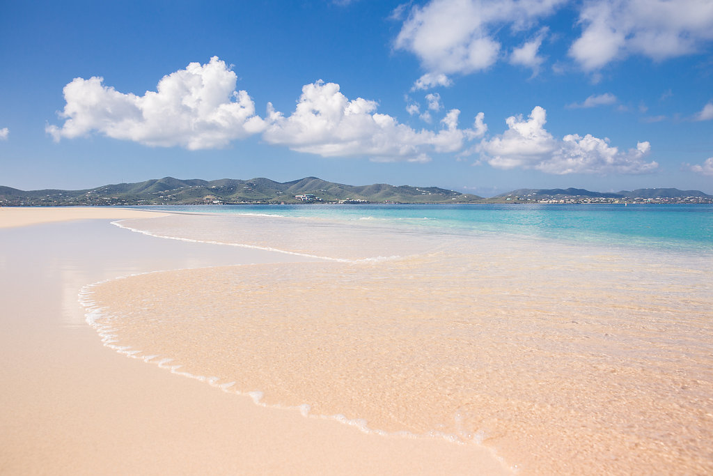 Pale sand and clear water with St. Croix's hills across the channel